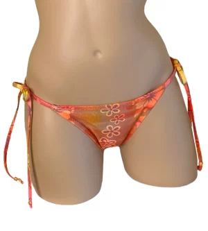 Low waist tie side ruched back bikini bottoms in orange holographic floral print with beads at strap ends